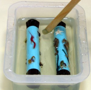 Resin casting tubes with fishing flies (left) and seahorses (right)